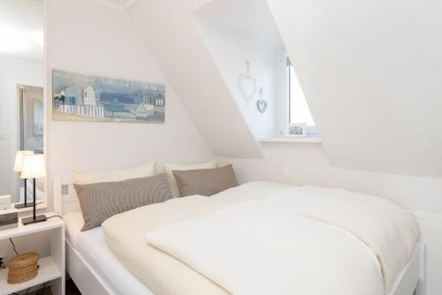 una camera bianca con un letto e una finestra di Meeresrauschen a Grömitz