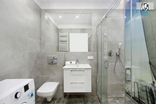 een badkamer met een douche, een toilet en een wastafel bij MS Apartments Sky Tower V in Gdańsk