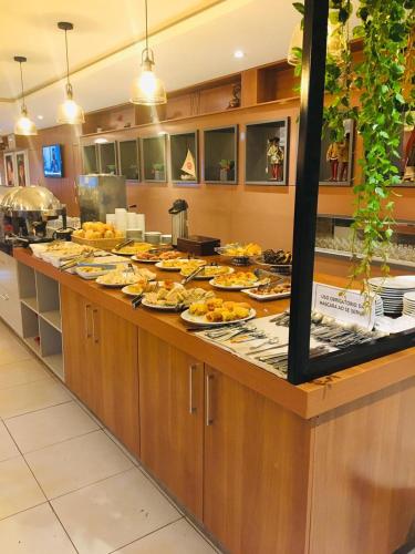 uma linha de buffet com muitos pratos de comida em Golden Ville Hotel em Marabá