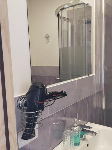 a bathroom sink with a hair dryer on a mirror at B&B Colti Di Rosa in Castelsardo