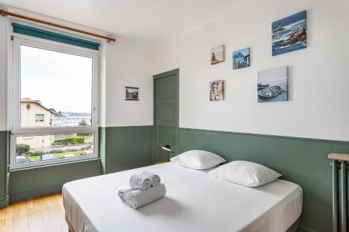 - une chambre avec un lit et des serviettes dans l'établissement Le Hauturier - appartement de standing avec vue mer, à Saint-Malo