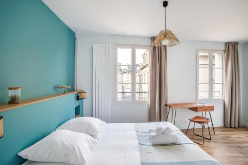 a blue bedroom with a white bed and a desk at Le Cap Cézembre - Intra-Muros Saint-Malo in Saint Malo