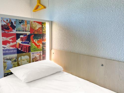 a bed with a white pillow in a room at hotelF1 Avranches Baie Du Mont Saint Michel in Saint-Quentin-sur-le-Homme