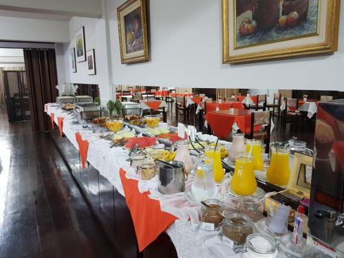 uma mesa longa com pratos de comida em Harbor Inn Jaraguá em Jaraguá do Sul