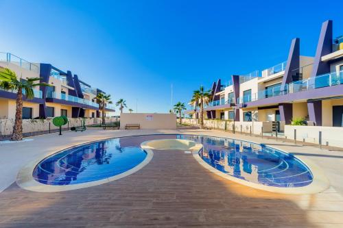 una piscina frente a algunos edificios de apartamentos en Luxurious 2 Bedroom Apartment near the beach, en Torre de la Horadada