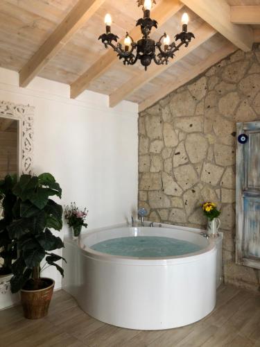 eine Badewanne in einem Zimmer mit einer Steinmauer in der Unterkunft Bay C in Alacati
