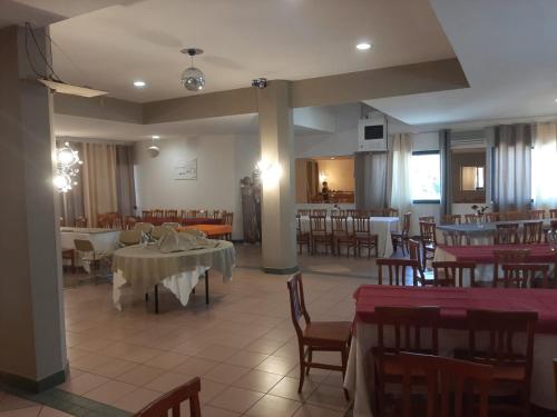 una sala da pranzo con tavoli, sedie e tavolo di Residence Palomba a Matera