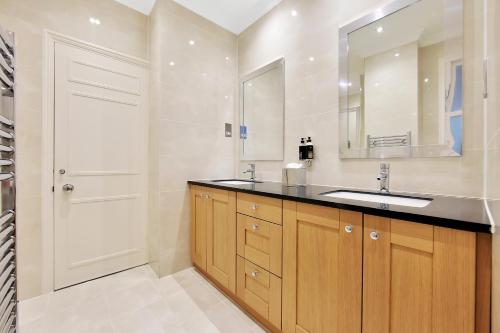 a bathroom with a sink and a mirror at No1 The Mansions By Mansley in London