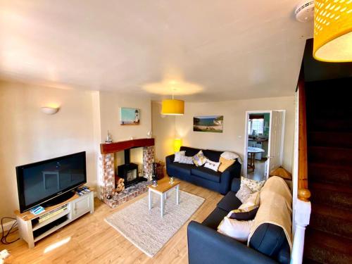 a living room with a blue couch and a fireplace at Hartendale in Flamborough