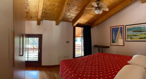a bedroom with a red bed and a ceiling fan at La Casa al Torrente in Riva del Garda