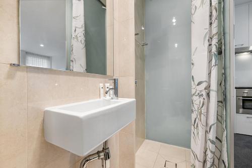 a bathroom with a white sink and a shower at Central City Studio Near Dining and Bars in Melbourne