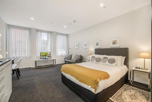 a large bedroom with a large bed and a television at Central City Studio Near Dining and Bars in Melbourne