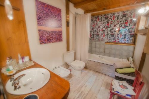 uma casa de banho com um lavatório, um WC e uma banheira em la casa del sol em San Carlos de Bariloche