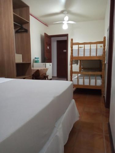 a bedroom with a bed and bunk beds at Pousada Japeju in Capão da Canoa