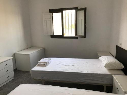 sypialnia z dwoma łóżkami i oknem w obiekcie CASA RURAL CABO de GATA-NÍJAR w mieście El Viso