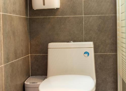 a bathroom with a white toilet in a tiled wall at 杏竹斋客栈 in Yi