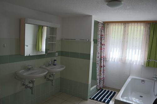a bathroom with two sinks and a shower at Harri's BnB in Kandersteg, Ferienwohnung in Kandersteg