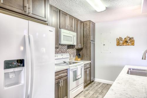 a kitchen with white appliances and wooden cabinets at Kauai Beach Villas D10 in Lihue