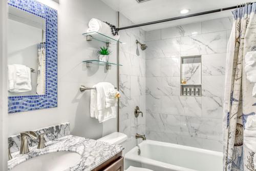 a bathroom with a tub and a sink and a shower at Kauai Beach Villas D10 in Lihue