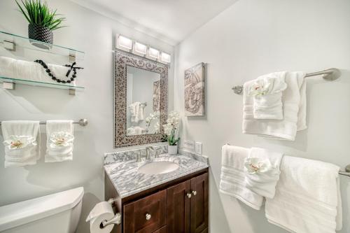 a bathroom with a sink and a mirror and towels at Kauai Beach Villas D10 in Lihue