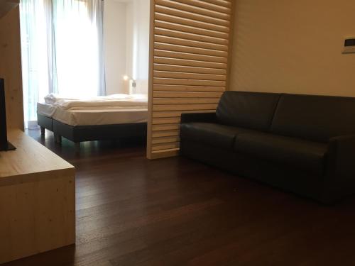 a living room with a couch and a bed at Komodo short stay apartments in Trento