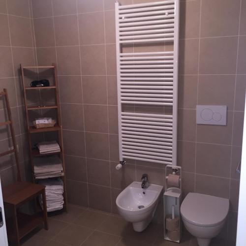a bathroom with a toilet and a sink at Komodo short stay apartments in Trento