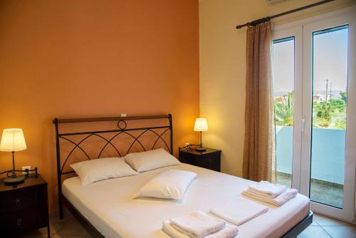 Un dormitorio con una cama con almohadas blancas y una ventana en Coastal Charm-Getaway to Artichoke's Seaside Oasis en Xerokampos