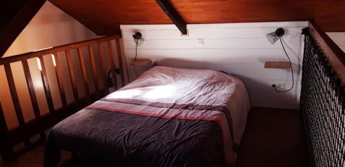 a small room with a bed in a attic at gite 2 ou 3 personnes - campagne in Bourbriac