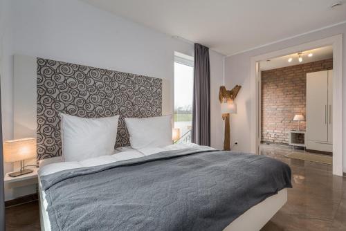 a bedroom with a large bed and a brick wall at Villa Bernstein in Börgerende-Rethwisch