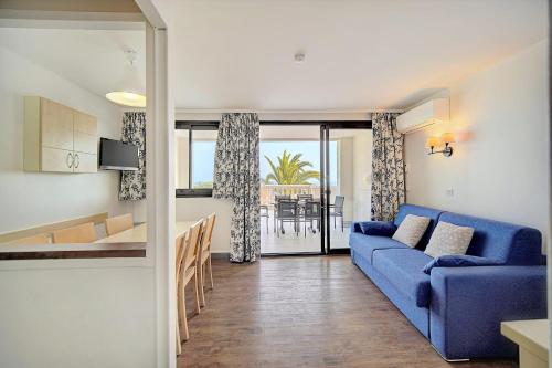 un salon avec un canapé bleu et une cuisine dans l'établissement IMMOGROOM - sea view - Pool - Terrace - Parking - Air conditioning, à Cannes