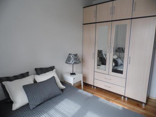 ソポトにあるKierunek Sopot Apartament POMORSKIのベッドルーム1室(ベッド1台、白い大型キャビネット付)