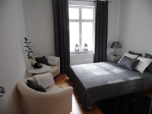1 dormitorio con 1 cama, 1 silla y 1 ventana en Kierunek Sopot Apartament POMORSKI, en Sopot