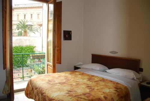 a bedroom with a bed and a door to a balcony at Hotel Conchiglia in Montecatini Terme