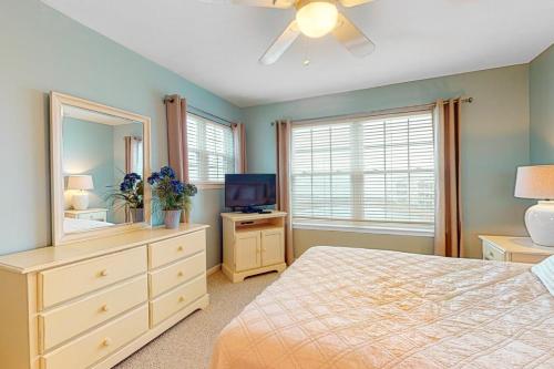 a bedroom with a bed and a dresser with a mirror at Bethany Bay 2505 Harbor Dr in Ocean View