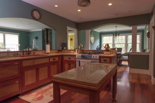a large kitchen with wooden cabinets and a table at The Gatehouse on Golden Hill in Lee
