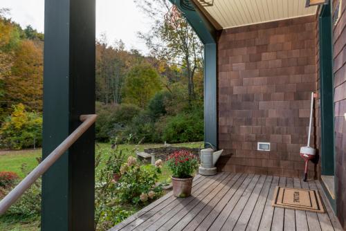 a porch with a wooden deck with a plant at The Gatehouse on Golden Hill in Lee