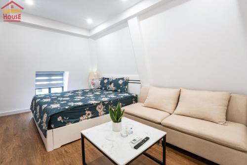 a living room with a couch and a bed at Merry House Imperia in Hai Phong