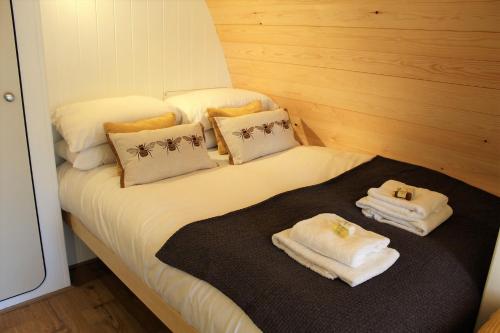 Una cama con toallas y almohadas encima. en The Honeybee Pod en Penrith