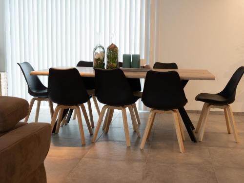 a dining room table with black chairs around it at Harbourskitchenhouse@sea in Bredene