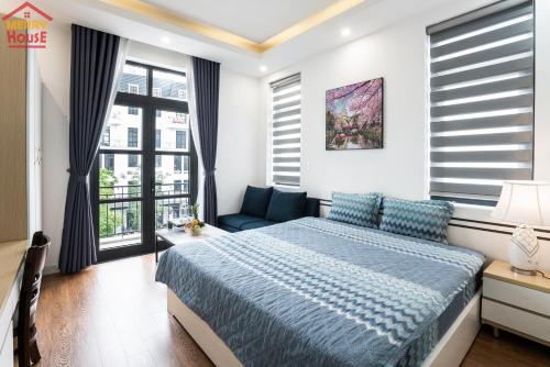 a bedroom with a bed and a couch and windows at Merry House Imperia in Hai Phong
