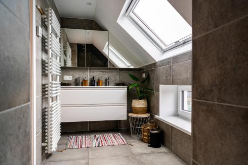 uma casa de banho com banheira e clarabóias em Harbourskitchenhouse@sea em Bredene