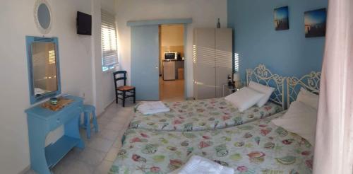 1 dormitorio con cama y pared azul en Hotel Glaros Lipsi en Lipsoi