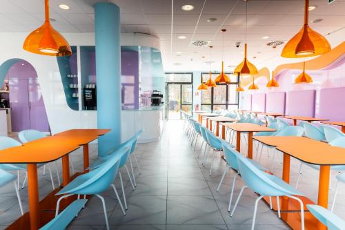 a row of tables and chairs in a restaurant at Prize by Radisson, Rostock City in Rostock