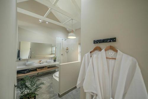 a bathroom with a white robe hanging on a rack at Little Kubu Lodge in Hoedspruit