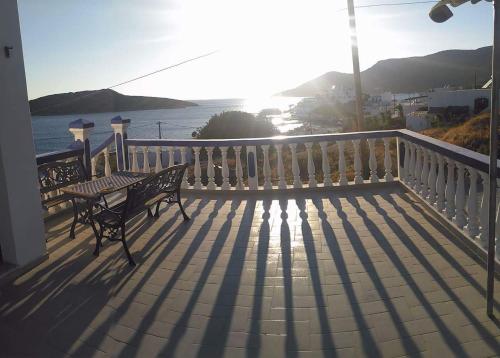 a balcony with a bench and a view of the ocean at Hotel Glaros Lipsi in Lipsoi