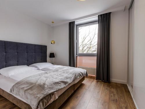 um quarto com uma cama grande e uma janela em VacationClub – Sand Hotel Apartament 305 em Colberga