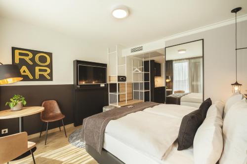 1 dormitorio con 1 cama, TV y mesa en the niu Leo - Apartments, en Núremberg