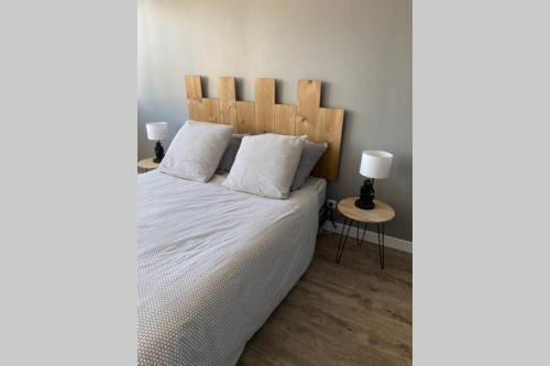 une chambre avec un grand lit avec une tête de lit en bois dans l'établissement Entre mer et falaises 2, au Tréport