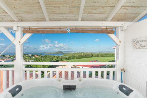 a hot tub on the balcony of a house at Bungalow Vanille Pacane - Vue Mer avec Spa Privé in Les Trois-Îlets