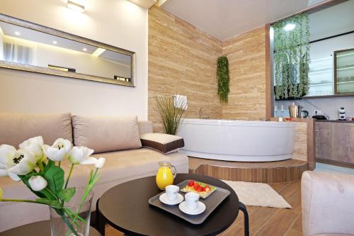 ベオグラードにあるCentral SPA Galaxy Apartmentのリビングルーム(バスタブ、テーブル付)
